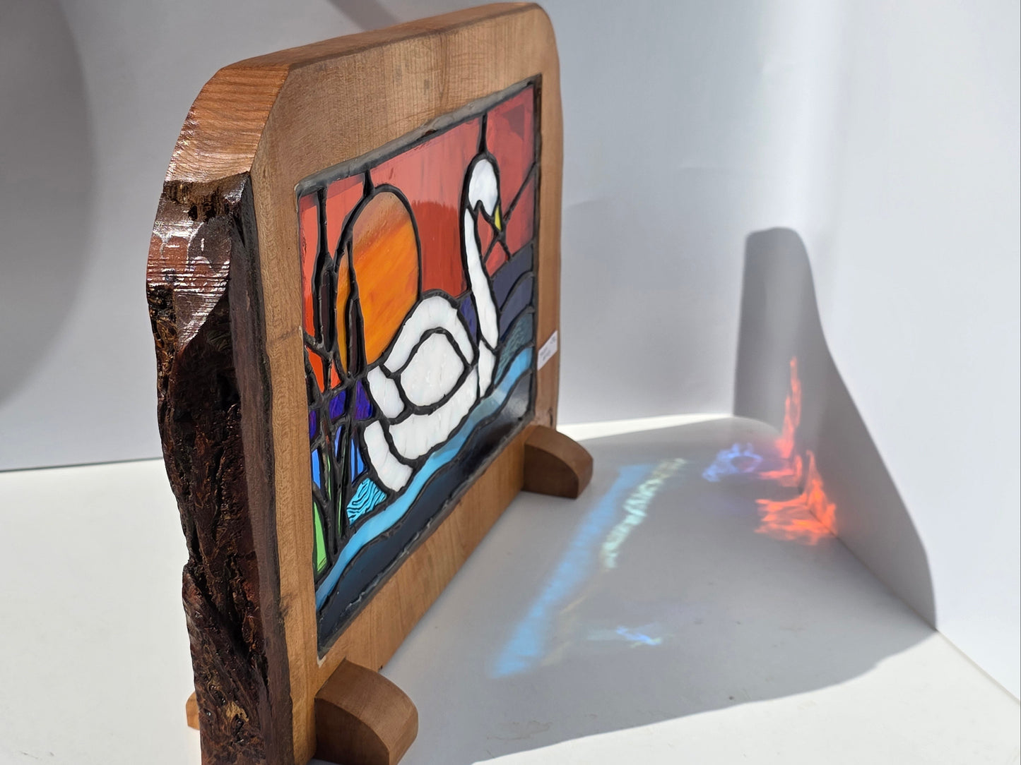 Stained glass 'Swan at Sunset' frames in a solid wood frame.