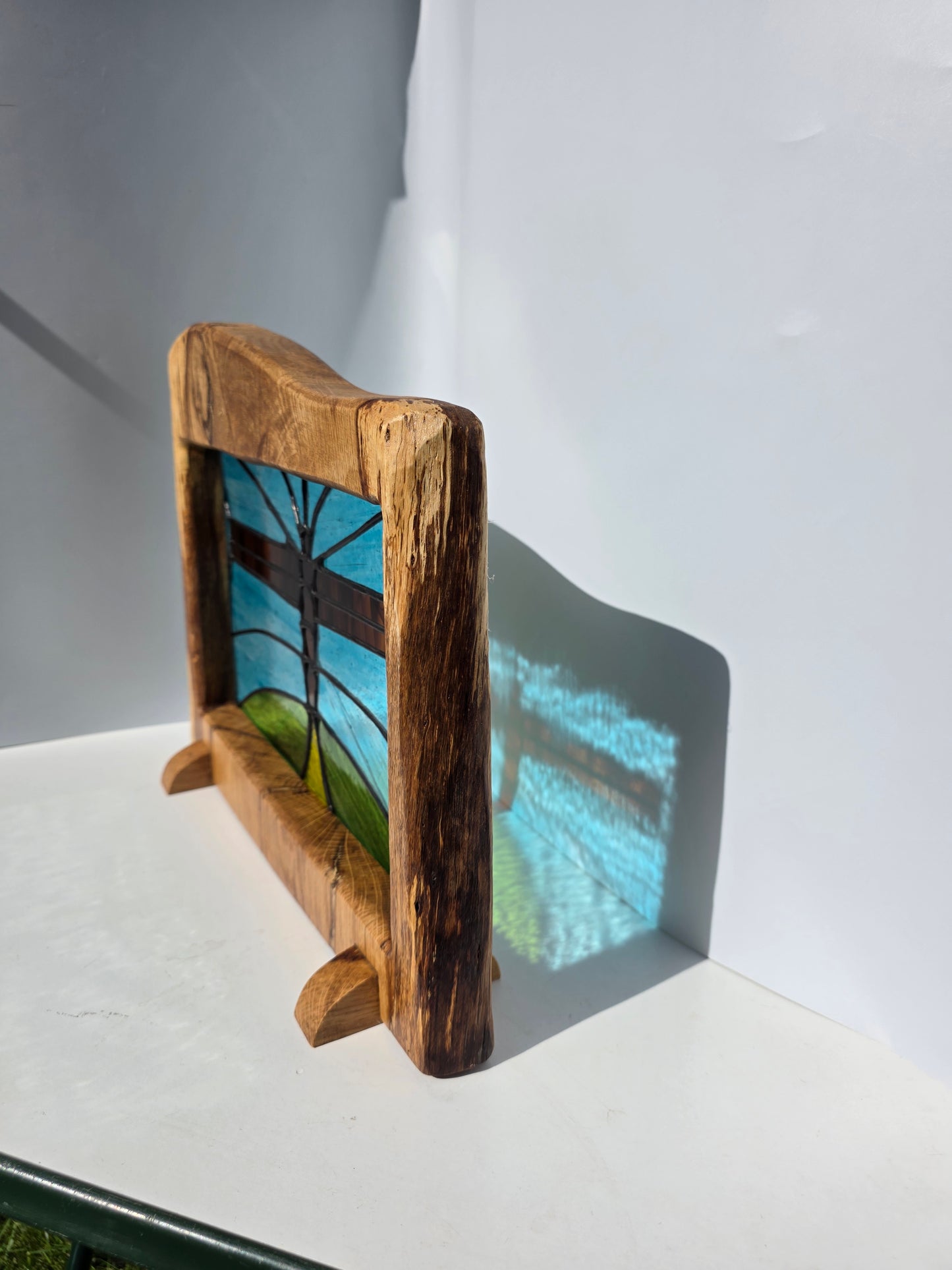 Stained glass 'Angel of the North' in a solid wood frame.
