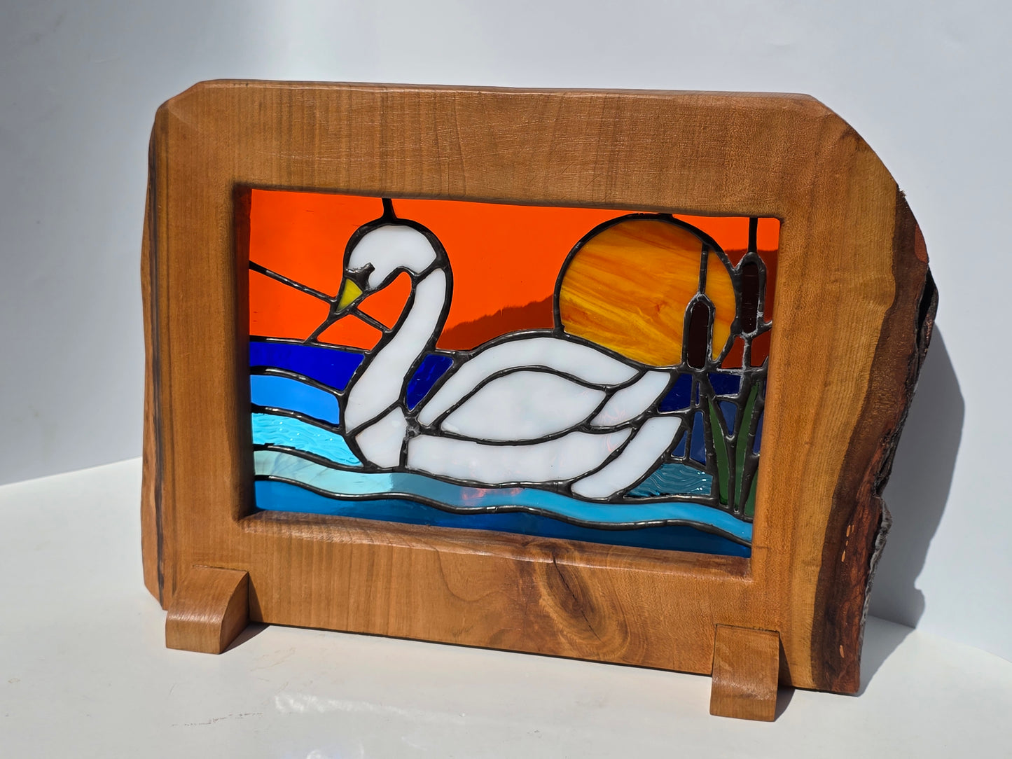 Stained glass 'Swan at Sunset' frames in a solid wood frame.