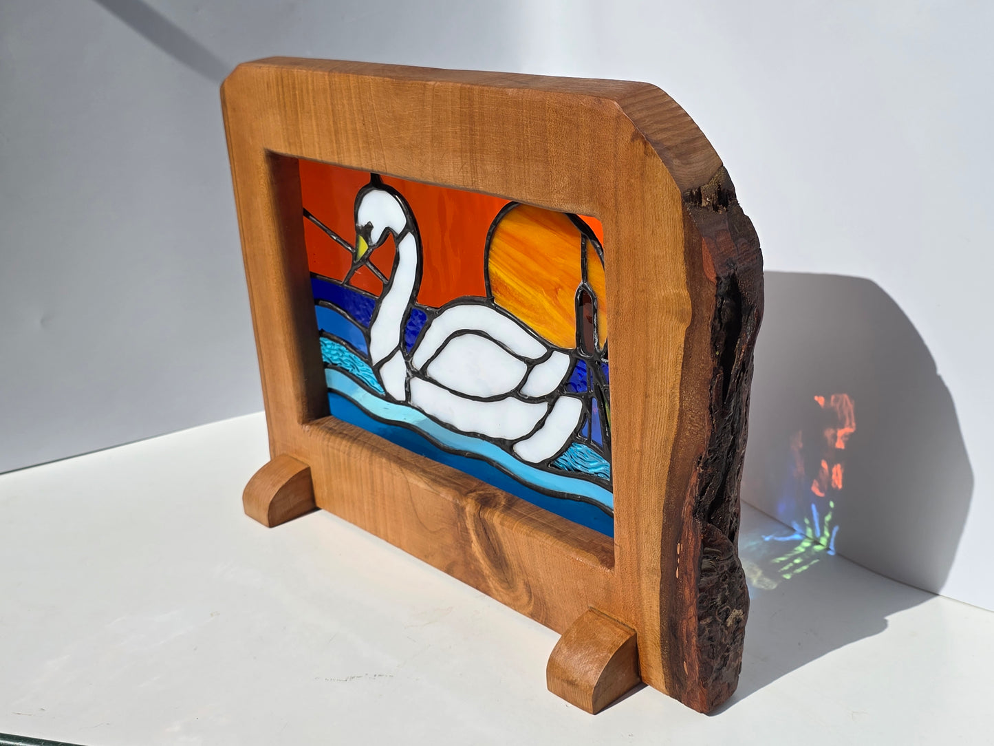 Stained glass 'Swan at Sunset' frames in a solid wood frame.