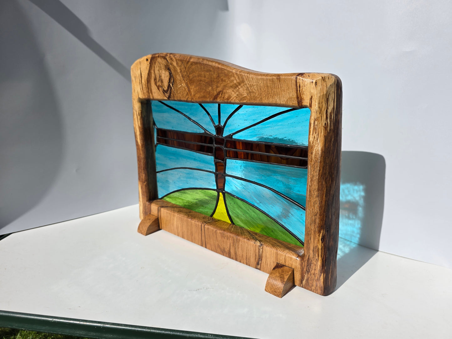 Stained glass 'Angel of the North' in a solid wood frame.