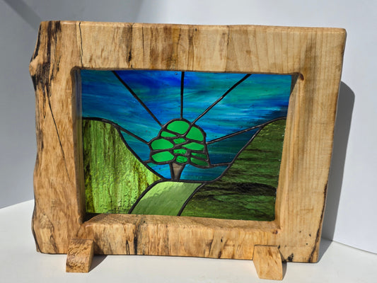 Stained glass 'Aurora at the Sycamore Gap' framed in solid sycamore wood.